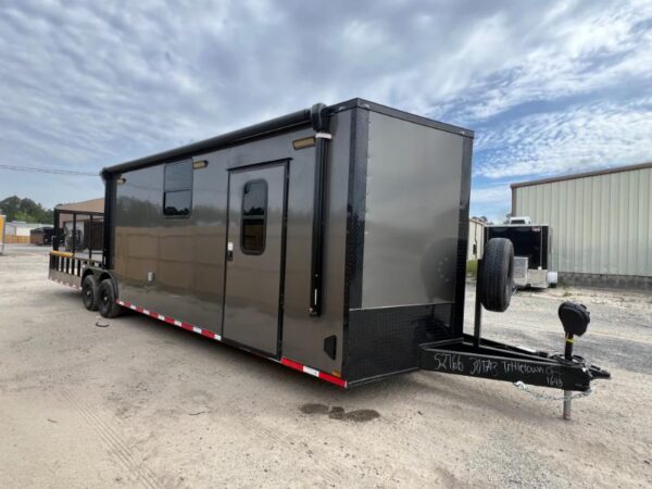 A gray 8.5x30TA hybrid enclosed trailer, shown from a front-side angle to highlight its dual-purpose design.