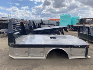 A Hillsboro STA500 Hybrid Truck Bed, a professional-grade flatbed with a mix of steel and aluminum components. The bed is black with a diamond-plate floor and a sturdy headache rack, and features a gooseneck ball and receiver hitch for towing.
