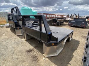 A Hillsboro STA500 Hybrid Truck Bed, a professional-grade flatbed with a mix of steel and aluminum components. The bed is black with a diamond-plate floor and a sturdy headache rack, and features a gooseneck ball and receiver hitch for towing.